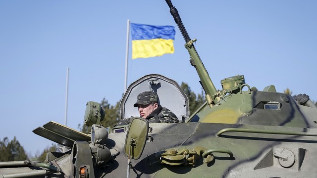 A Ukrainian soldier rides on an armoured personnel carrier during a military exercise near the village of Goncharivske